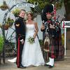 Image of a bride, groom and piper