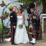 Image of a bride, groom and piper